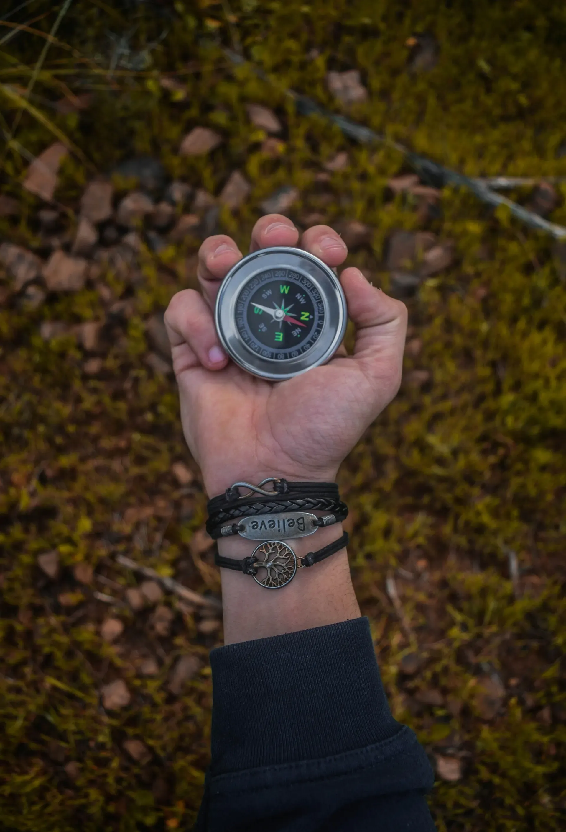 Eine Hand hält einen Kompass in der Natur